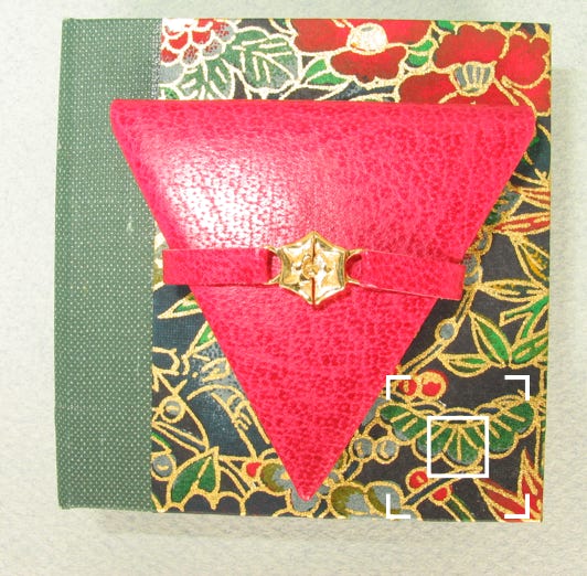 Fron cover showing strap closure with rose, on chiyogami covered book box